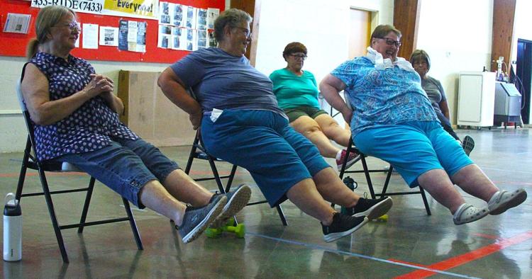 Residents share a laugh while doing leg exercises